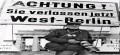 vor dem Hinweisschild, Achtung sie verlassen jetzt West-Berlin